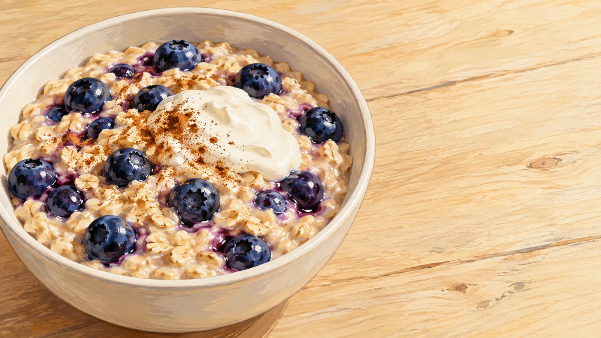 One bowl of creamy blueberry oats with a small spoonful of yogurt in a wide wooden-table scene.